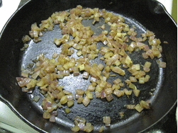 A cast iron pan of diced onions after being steam sauteéd